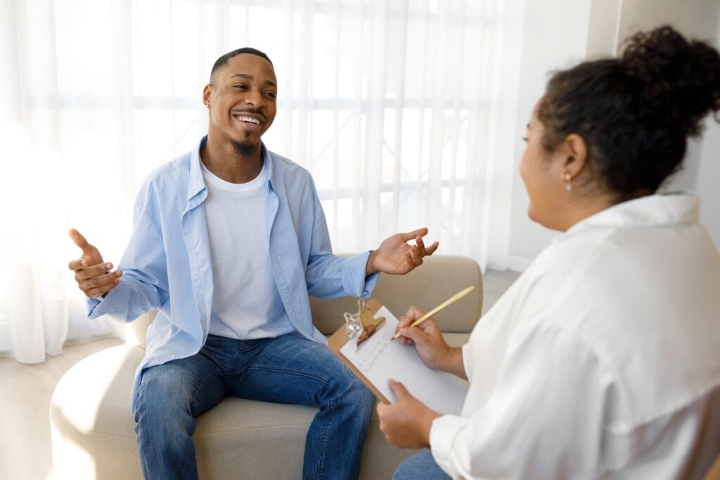 A man discusses insurance options with his therapist during south jersey benzodiazepine addiction treatment.