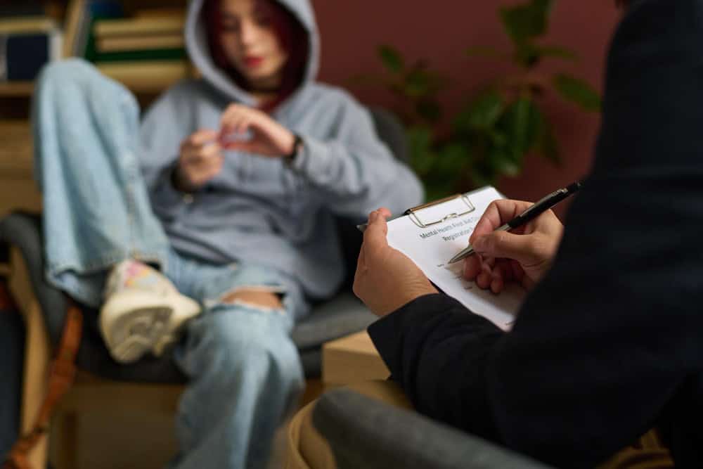 Therapist taking notes during south jersey Ritalin addiction treatment session with teenager