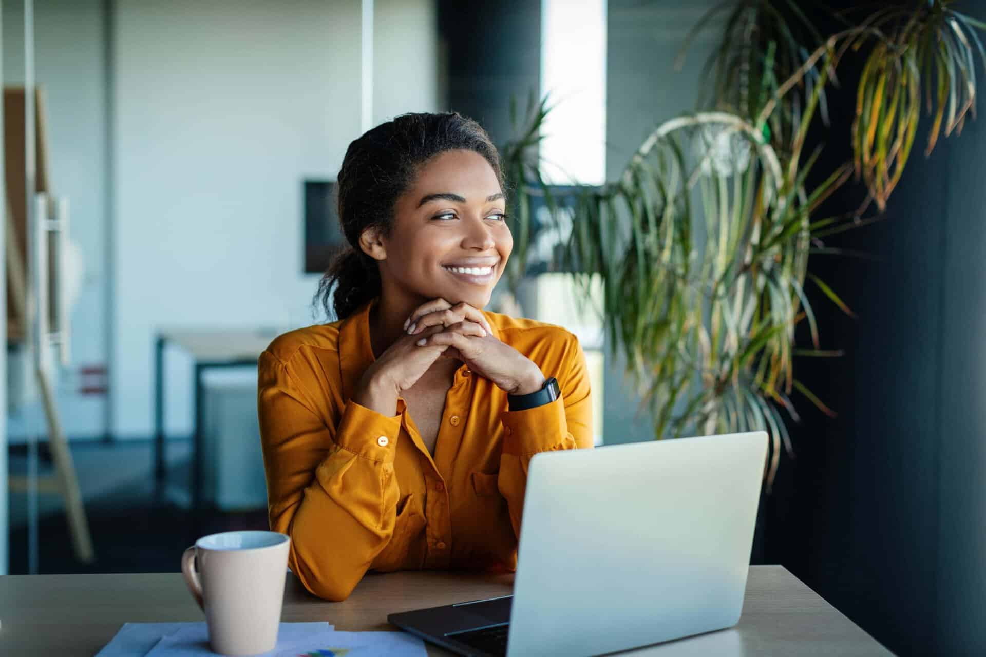 Woman smiling while working from home as part of a healthy lifestyle supported by rehab near Barnegat Township, NJ and addiction recovery in Barnegat, NJ with Shorebreak Recovery.