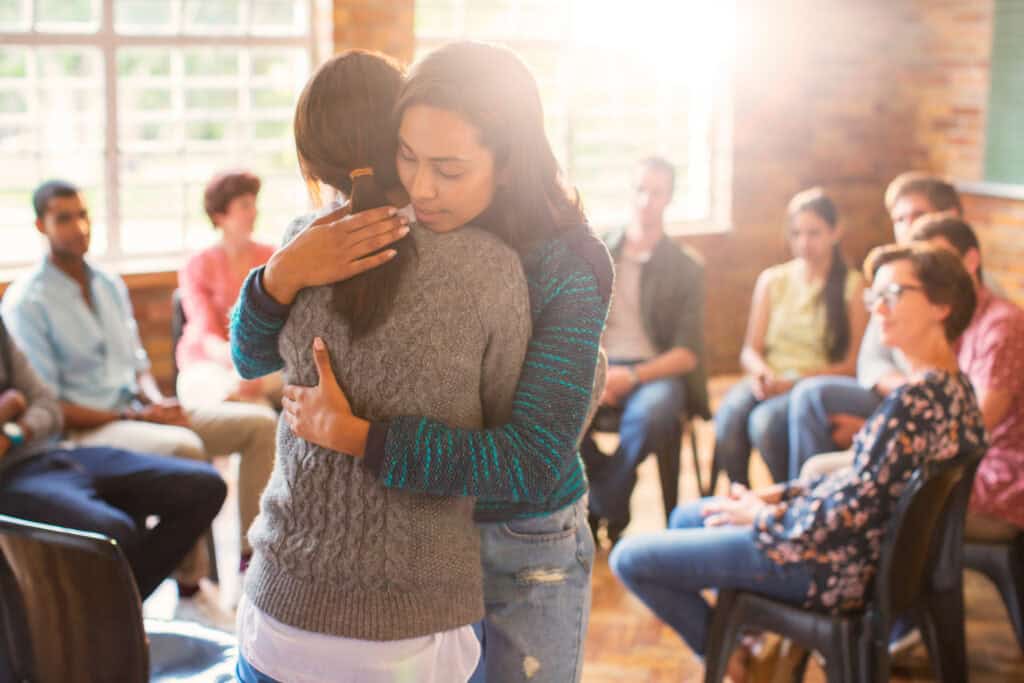 Two women hugging during a group therapy session for LSD addiction treatment in NJ